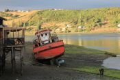 Barco varado en Chiloé, con las mareas el mar puede recogerse mas de 100 metros, dejando a los botes varados Guía de Chiloe, CHILE